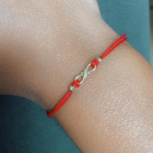 Braccialetto in filo rosso ed elemento infinito in oro 14 carati
